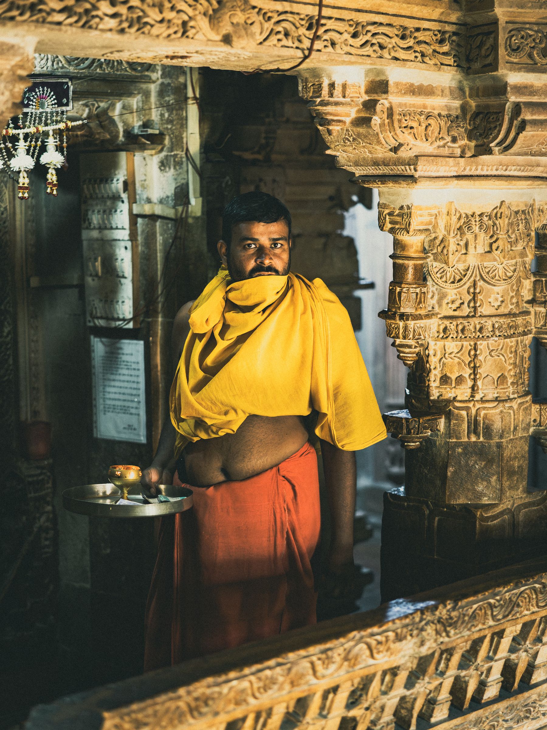 Priest Holding Lamp and Collection Plate
